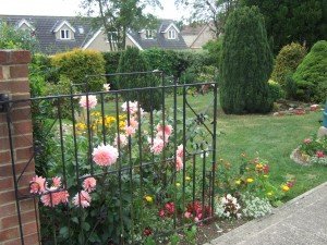 Garden gate, leading to lawn, flower beds and shrubs