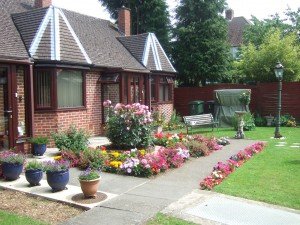 Colourful front garden with plants in pots and beds