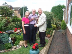Couple standing in developed garden with Chairman of Parish Council